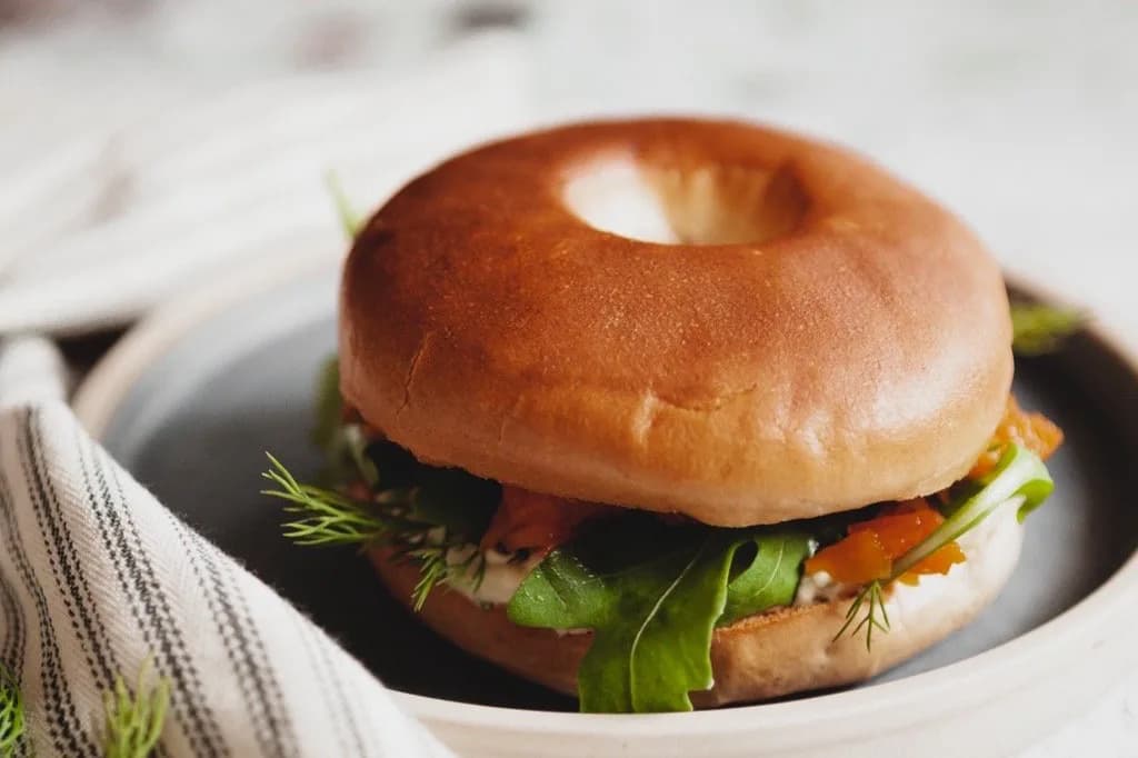 Toasted bagel filled with rocket, dill and roasted vegetables