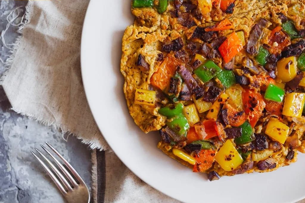 Pepper and red onion scramble on a white plate